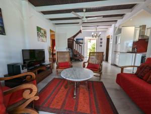 a living room with a red couch and a table at Villa Monet in Sainte-Rose