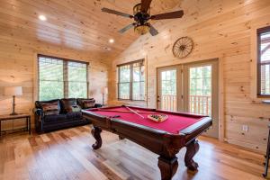 una mesa de billar en una habitación con ventilador de techo en Smoky Haven en Gatlinburg