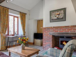ein Wohnzimmer mit einem gemauerten Kamin und einem Tisch in der Unterkunft The Dairy in Kingsbridge