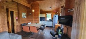 a dining room with a table and a kitchen at Familie bungalow Sundsvall in Gramsbergen