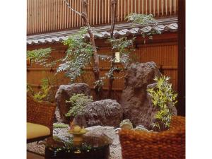 kamogawa Kan - Vacation STAY 17163v في كيوتو: حديقة فيها صخور ونافورة في مبنى