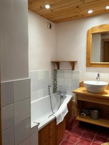 ein Badezimmer mit einer Badewanne und einem Waschbecken in der Unterkunft Le Chalet Hôtel Cordon Adults Only in Cordon