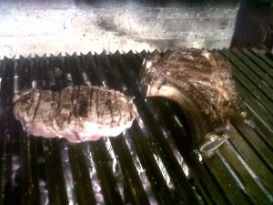 a piece of meat is cooking on a grill at El Cabañon de Pimiango in Pimiango