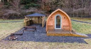 a small wooden cabin with a picnic table and a gazebo at Glamping Pod 2 Magical Craigengillan Estate in Dalmellington