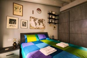 um quarto com uma cama colorida e toalhas em La Mansarda Vintage em Moncalieri