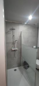 a bathroom with a glass shower with a toilet at L'escale tout confort in Charleroi