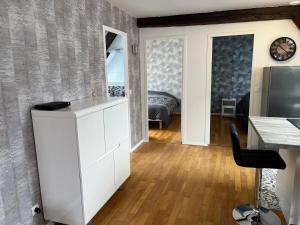 a living room with a white cabinet and a bedroom at Coeur de bouchon in Troyes