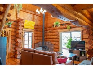 - un salon avec un canapé et une cheminée dans une cabane en rondins dans l'établissement Inaka no Kakurega Cottage Hideaway - Vacation STAY 19620v, à Inakadate