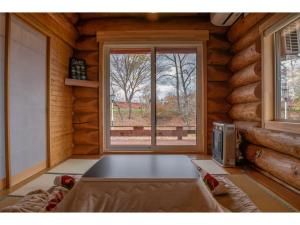a room with a large window in a log cabin at Inaka no Kakurega Cottage Hideaway - Vacation STAY 19620v in Inakadate