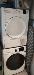 a microwave oven sitting on top of a machine at Escale Tout Confort Maison entière Parking gratuit Proche Aéroport Charleroi in Charleroi