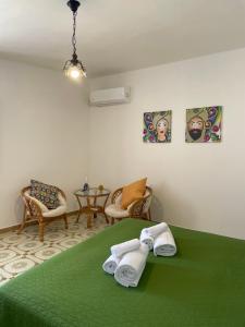 a room with a green bed with towels on it at Appartamento L'Agnuni in Castellammare del Golfo +24 photos