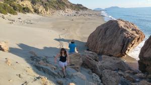 Un uomo e una donna in piedi su una spiaggia di The Village House a Kerames