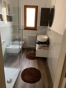 uma casa de banho com uma cabina de duche em vidro e um lavatório. em Piazzetta della Croce em Anghiari