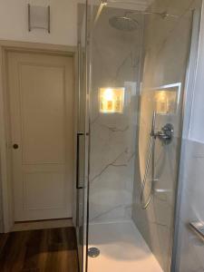 uma casa de banho com um chuveiro e uma porta de vidro em Piazzetta della Croce em Anghiari