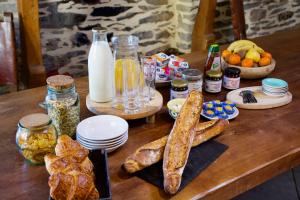 uma mesa de madeira com pão e outros alimentos em Valfrescos - Lac de Guerlédan em Caurel