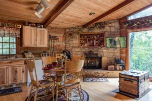 a kitchen with a table and a stone fireplace at Rustic Charm in Gatlinburg