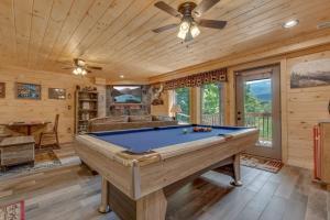 a pool table in a room with a ceiling fan at Rustic Charm in Gatlinburg