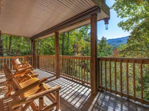 a deck with chairs and a view of the mountains at Rustic Charm in Gatlinburg