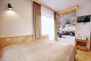 sypialnia z dużym łóżkiem i dużym oknem w obiekcie Pokoje Gościnne Stanek w Zakopanem