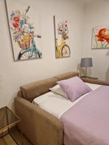 een bed en een bank in een kamer met schilderijen bij Casinha Azul in Lagos