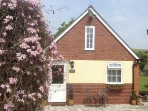 韦茅斯Pump Lodge的前面有粉红色花的房子