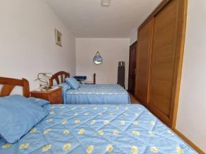 1 dormitorio con 2 camas y edredón azul en Apartamento cerca de la playa, en Pontevedra