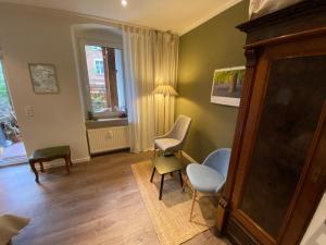 sala de estar con sillas, mesa y ventana en Harry's Apartment en Erfurt