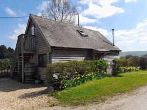ClunにあるBicton Lodgeの花の前にある古い木造家屋