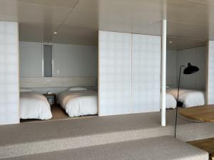 a bedroom with two beds and a mirror at Cliff House MORAI - Vacation STAY 14408 in Ishikari