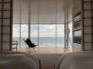 - une chambre avec un lit et une vue sur l'océan dans l'établissement Cliff House MORAI - Vacation STAY 14408, à Ishikari