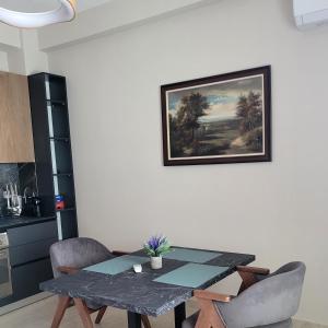 tavolo da pranzo con sedie e dipinto sul muro di @Bazaar a Tirana