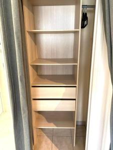 ディジョンにあるLa Station - À proximité immédiate de la gareの木製の棚とカーテン付きのクローゼット