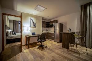 a room with a desk and a kitchen with a refrigerator at Wyndham Garden Guatemala City in Guatemala