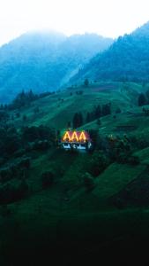 una casa iluminada en una colina en un campo en Bungi dağ evleri en Rize
