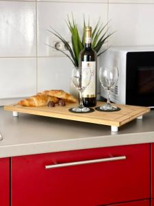 a cutting board with a bottle of wine and glasses at R&B apartment in Timişoara