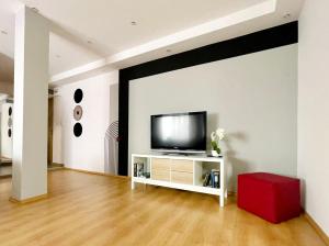 a living room with a television on a white wall at R&B apartment in Timişoara