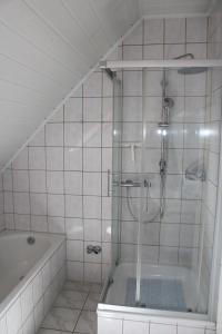 a bathroom with a shower and a bath tub at Ferienwohnung Wegmann in Borkum +6 photos