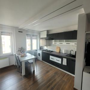 a kitchen with a table and a stove and a sink at Mieszkanie centrum in Lidzbark Warmiński