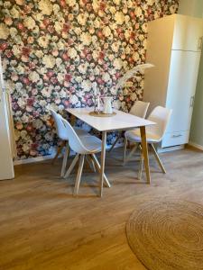 a table and chairs in a room with a floral wall at Ferienwohnung Luzi am Radweg Kanonenbahn in Küllstedt