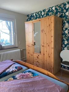a bedroom with a wooden cabinet and a bed at Ferienwohnung Luzi in Küllstedt