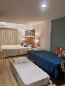 a hotel room with two beds and a couch at Flats Pipas Bay - BEIRA MAR in Pipa