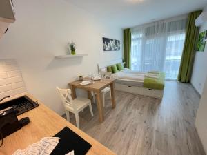 1 dormitorio con cama, mesa y escritorio en Siesta Apartman, en Balatonberény