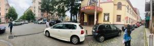 a white car parked on the side of a city street at Apart voyage in Batumi
