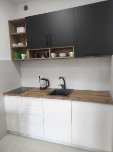 a kitchen with white cabinets and a sink at Studio K in Podgorica