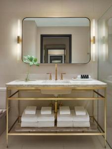 ein Bad mit einem Waschbecken und einem Spiegel in der Unterkunft 11 Howard, New York, a Member of Design Hotels in New York