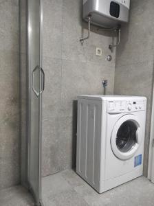 a washer and dryer in a corner of a bathroom at Studio K in Podgorica
