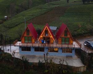 duży drewniany dom z werandą na wzgórzu w obiekcie Bungi dağ evleri w mieście Rize