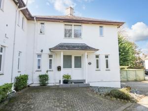 ein weißes Haus mit einer steinernen Einfahrt in der Unterkunft Kempton in Bowness-on-Windermere