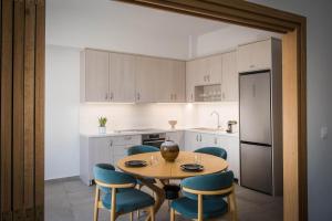 a kitchen with a table and chairs and a refrigerator at Loggia Suites by Good Life in Heraklio