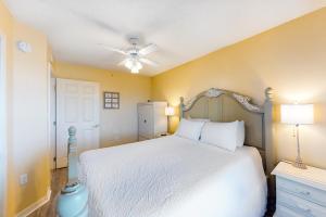 1 dormitorio con cama blanca y ventilador de techo en Islander Beach Resort unit 3009, en Fort Walton Beach
